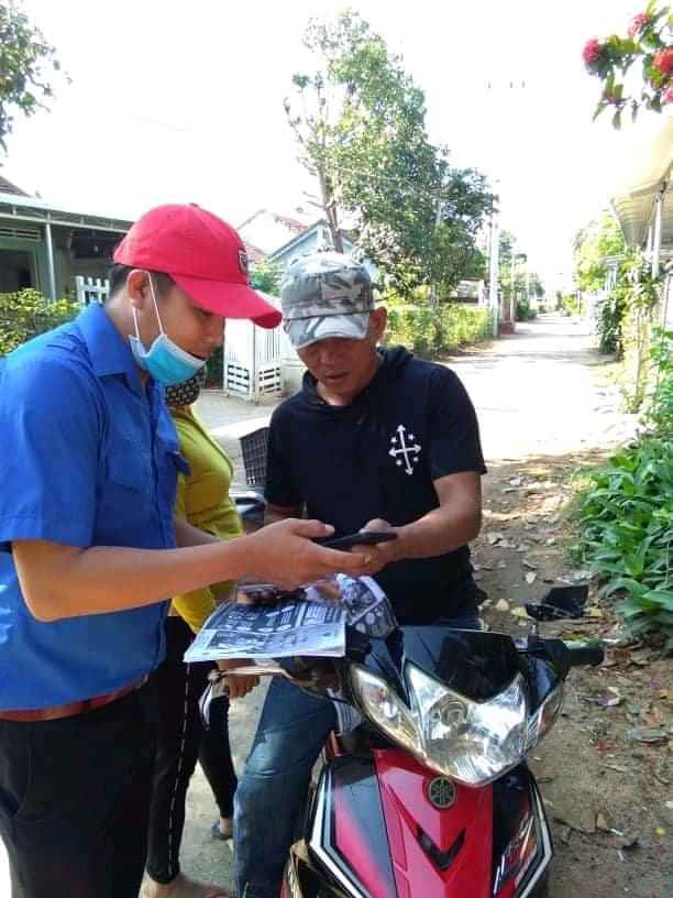 Đồng chí Lê Trịnh Đời Bí thư Đoàn TNCS Hồ Chí Minh xã phát tờ rơi tuyên truyền và hướng dẫn người dân sử dụng khai báo sức khoẻ y tế tự nguyện NCOVI